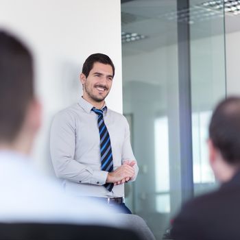 Relaxed cheerful team leader and business owner leading informal in-house business meeting. Business and entrepreneurship concept.