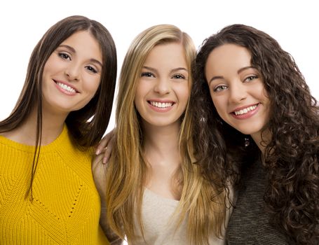 Studio portrait of three beautiful teenage girls smiling