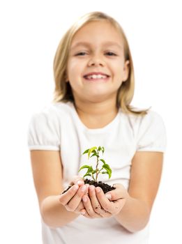 Happy little girl showing a plant on her little hands