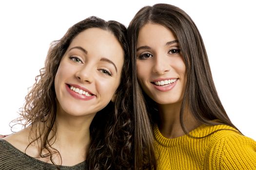 Studio portrait of two beautiful girls smiling