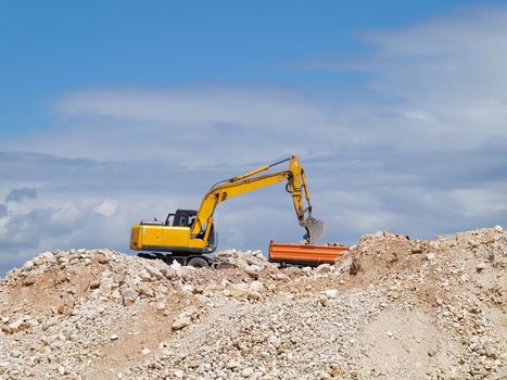 excavator loading tipper truck on construction site