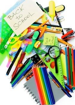 Back to School Concept with Various Stationery Items, Paint Brushes, Felt In Pens, Erasers, Note Pads and Lines closeup on white background