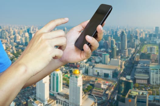 Hand of Young adult Tourist use Mobile Device smartphone over City Building Background