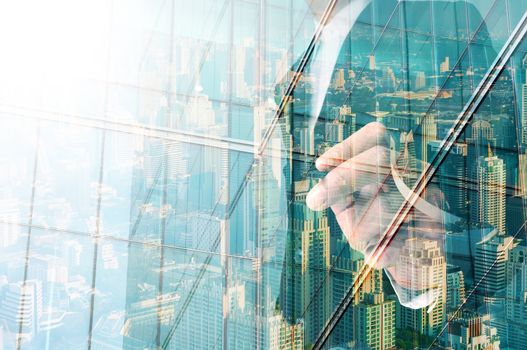 businessman writing something on transparent board with city reflection, double exposure