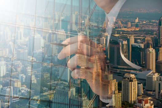 businessman writing something on transparent board with city reflection, double exposure