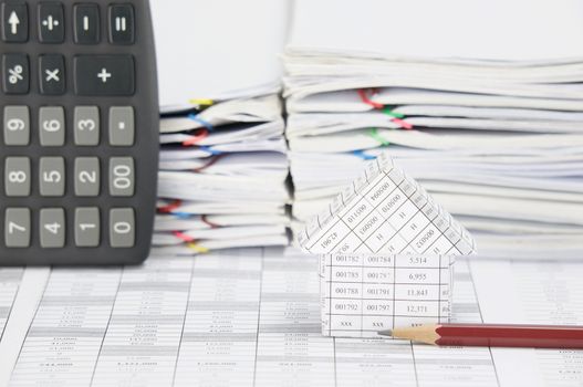 House with brown pencil on finance account have blur calculator place vertical and overload of paperwork with colorful paperclip as background.