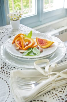 Presentation of fruit, slice of orange with almond 
