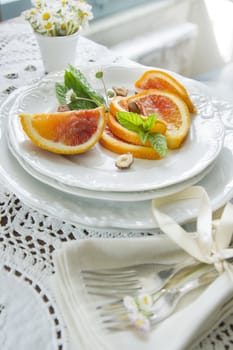 Presentation of fruit, slice of orange with almond 
