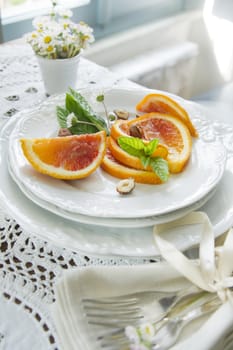 Presentation of fruit, slice of orange with almond 
