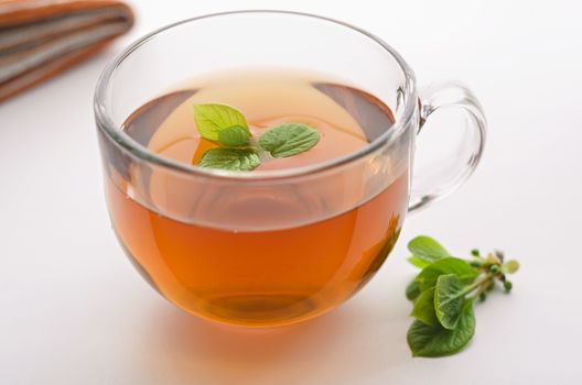 Cup of tea with lemongrass leaves and the leaves are on the table, natural light, bokeh.