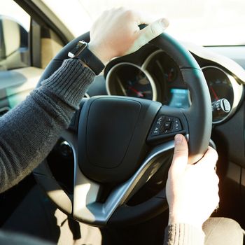 Closeup Of A Man Hands Holding Steering Wheel While Driving Car with retro filter effect