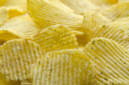 Potato chips striped with greens. Background of potato chips, close-up.