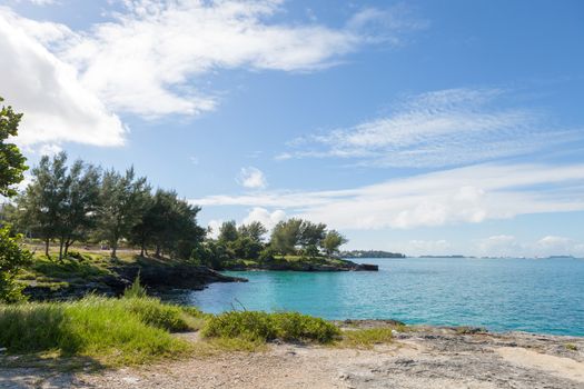 Bermuda coast with aqua blue tropical waters and rock formations complete with small caves.