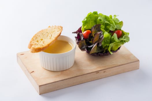 Corn soup in ceramic cup with toast and freash vegetables on wood plate. Clean and healthy eating concept food.