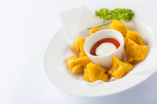 Chinese style deep-fried wonton with sweet and sour sauce in ceramic dish.