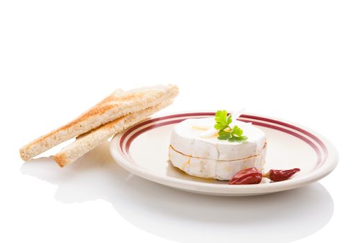 Delicious marinated camembert cheese on plate isolated on white background. Traditional czech cheese eating.