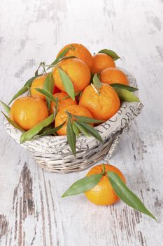 Mandarine fruit in white wooden basket on white wooden table. Provence style.