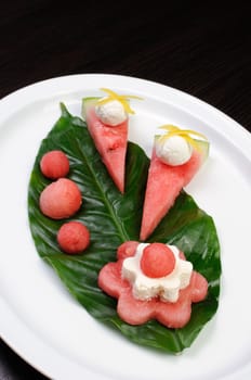 Decorative design of watermelon snack with ricotta on a green leaf