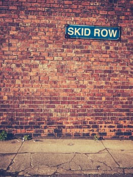 Urban Decay Image Of A Skid Row Sign On A Red Brick Wall