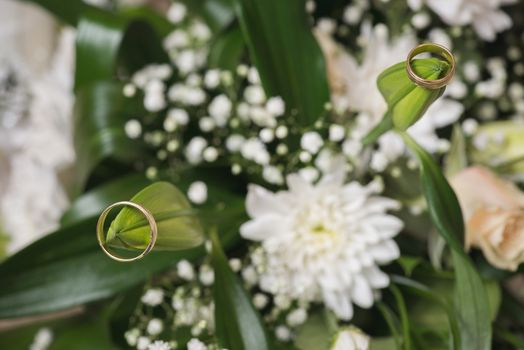 Wedding rings  laying on  bouquet. Macro shot.