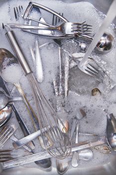 Sink with cutlery ready to be washed