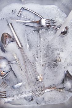 Sink with cutlery ready to be washed