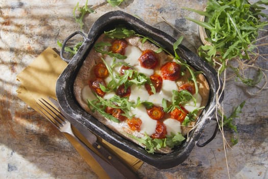 Tricolor pizza with tomato mozzarella and fresh arugula 