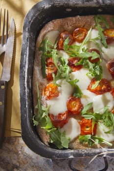 Tricolor pizza with tomato mozzarella and fresh arugula 