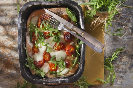 Tricolor pizza with tomato mozzarella and fresh arugula 