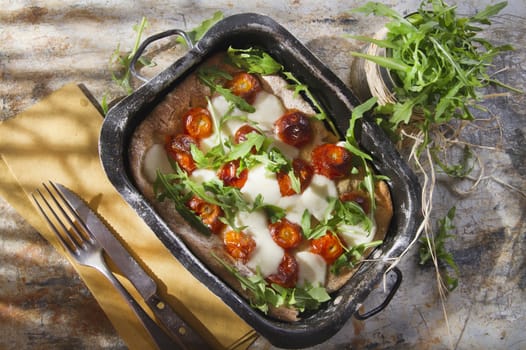 Tricolor pizza with tomato mozzarella and fresh arugula 