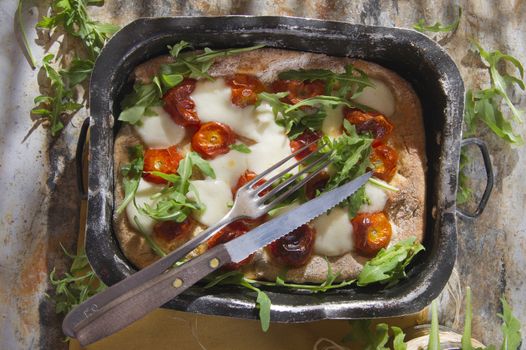 Tricolor pizza with tomato mozzarella and fresh arugula 