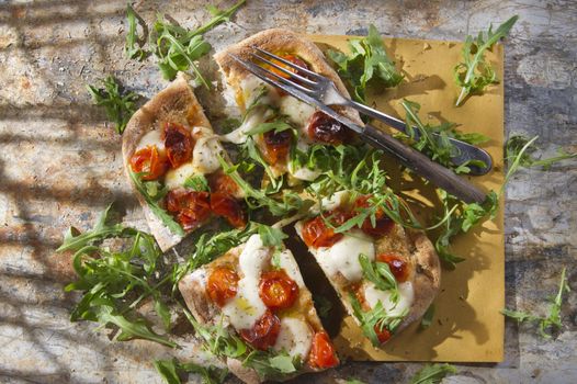 Tricolor pizza with tomato mozzarella and fresh arugula 