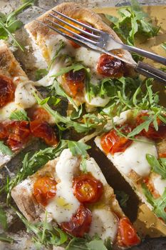 Tricolor pizza with tomato mozzarella and fresh arugula 