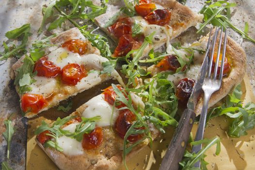Tricolor pizza with tomato mozzarella and fresh arugula 