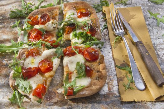 Tricolor pizza with tomato mozzarella and fresh arugula 