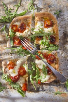 Tricolor pizza with tomato mozzarella and fresh arugula 