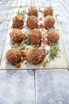 According plate of meatballs and baked potatoes