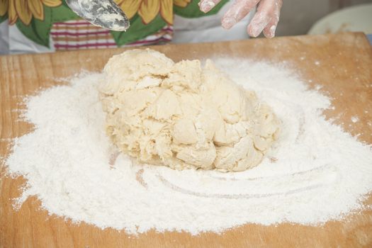 Women's hands preparing fresh yeast dough on wooden table