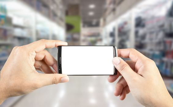 Hand holding smart phone with blur background of shopping mall market, business financial or shopping concept