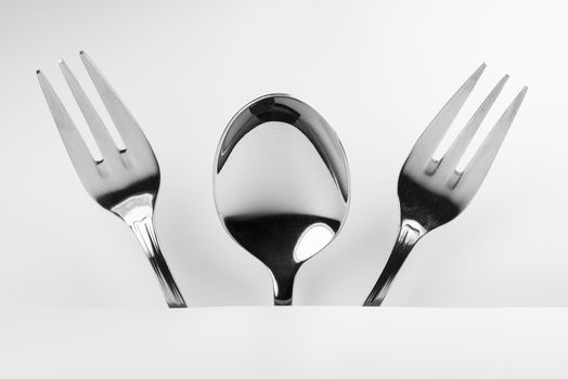Metal spoon and two metal forks formed into a frightning conceptual fantasy figure

