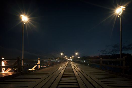Utamanusorn Bridge (Mon Bridge), made from wooden for across the river at night, Sangkhlaburi District, Kanchanaburi Thailand