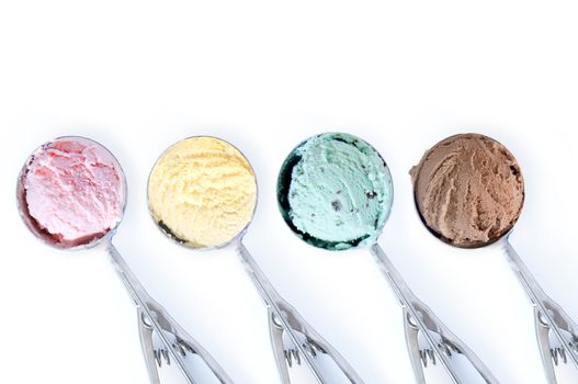Close up of four flavored ice cream scoops over a white background