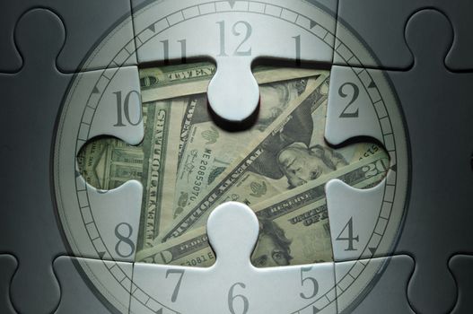 Missing piece from a clock jigsaw puzzle with dollar banknotes in the center