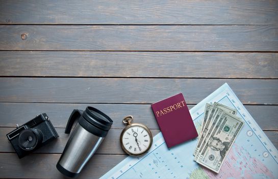 Travel objects on a wooden background with passport, camera and map