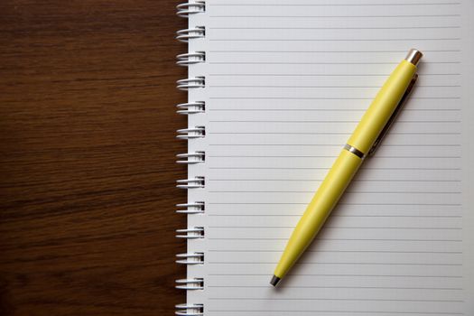 Blank notebook paper on wooden desk background