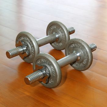 Dumbbell with plates on a wooden deck