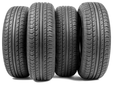 Stack of four wheel new black tyres for summer car driving isolated on white background