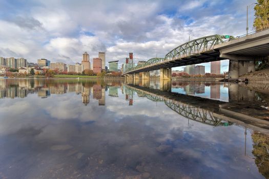 Reflection of Portland Oregon downtown city skyline by Hawthorne Bridge on Willamette River daytime