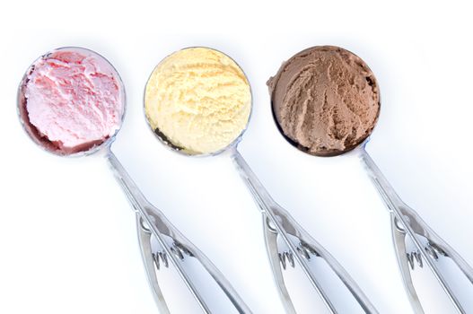 Close up of three flavored ice cream scoops over a white background