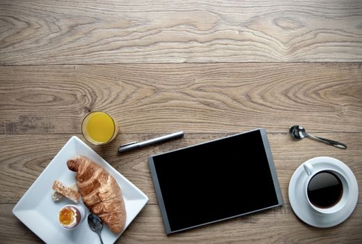 Breakfast with digital tablet on a wooden background with space